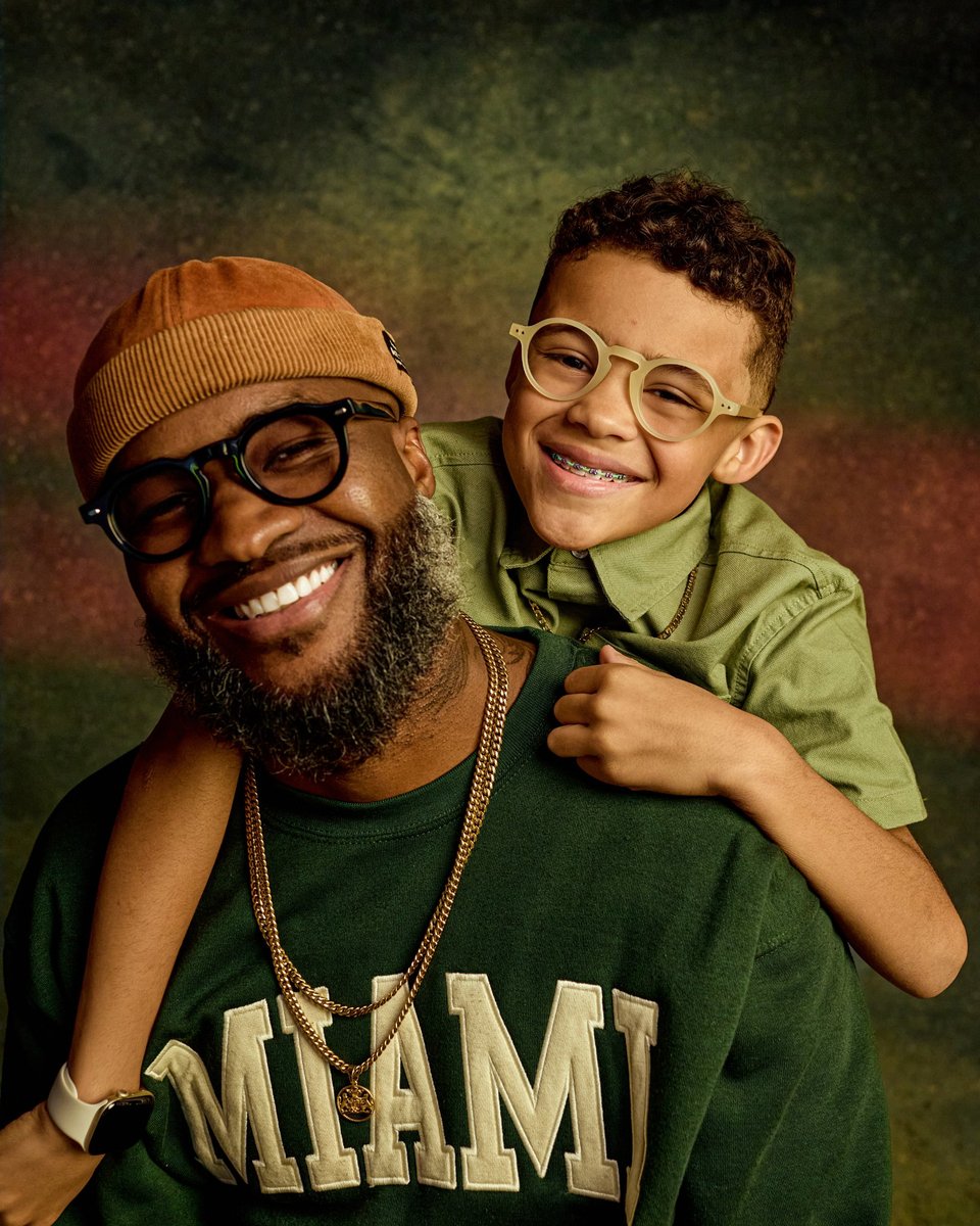 Adrian and Bryson smiling together, Bryson riding on his dad's back
